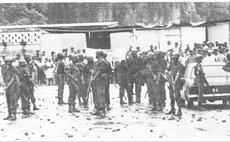 After the tear gas and the stones members of the Defence Force stand near Government Headquarters on Kennedy Avenue