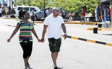 Tourists hold hands on the Roseau Bay Front