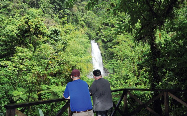 Two tourists look at one of the two Trafalgar waterfalls