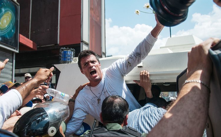 Venezuelan opposition leader Leopoldo Lopez (C) reacts after handed himself over to the police, Caracas, Venezuela, on Feb. 18, 2014. Leopoldo Lopez, wanted by authorities on charges of inciting viole
