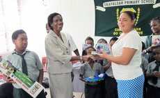 Ms White, centre, presents gifts to Trafalgar School
