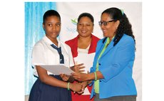 Ms Rolle of Sagicor hands prize to St Martin's School Student Ms Francois